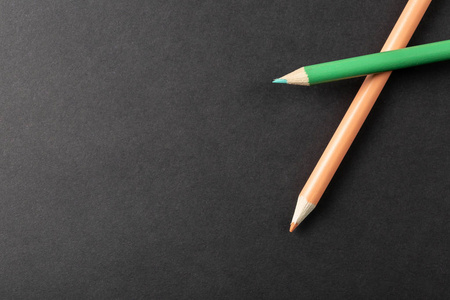 灰色背景俯视图上的两支彩色铅笔。