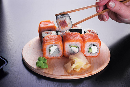 深色加州加州寿司卷在深色的木桌上照片