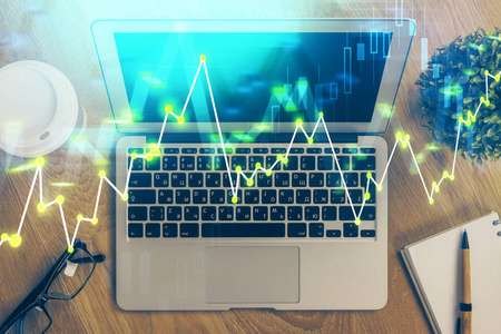 具有电脑背景的图形财务信息和工作空间的双重曝光。国际网上交易的概念。