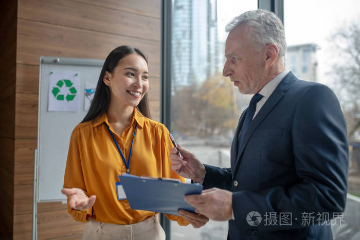 年轻的女助理微笑着对白发苍苍的老板微笑