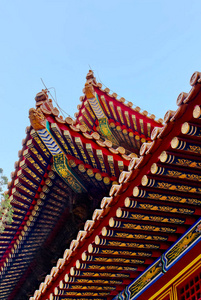 北京故宫紫禁城。中国传统风格的弧形屋顶，蓝天背景上有人物
