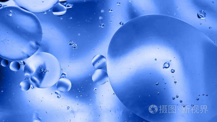 用油水和肥皂制成的散焦抽象背景图片。蓝色调。