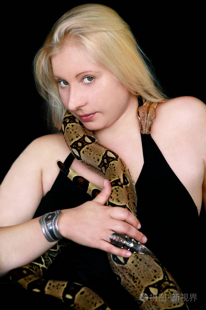 女孩与蟒蛇的肖像.美女双手捧着蛇,在镜头前摆姿势.