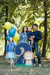 家庭生活。公园里父母和孩子的肖像。一个两岁男孩的生日。第二个是狮子和气球。