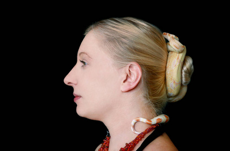 无毒的大蟒蛇,白化蛇类,在她的头发上滑行爬行,并将自己包裹在一簇