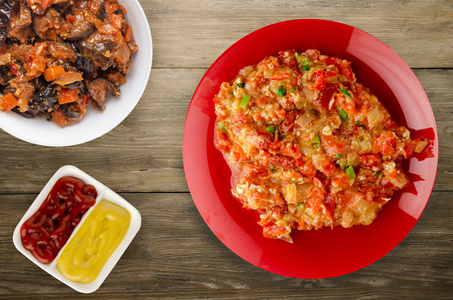 Stewed tomatoes with onions in a plate on a wooden background 