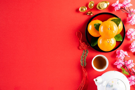 中国新年的装饰物有红色的小包橙色和金色的锭或金色的块状物。文章中的汉字赋指的是好运好运财富金钱的流动。