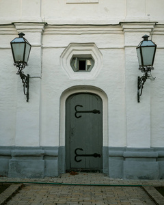 Oldstyle closed wooden doors in a stone wall which are adorned 