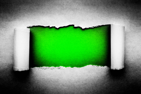 复古纸上的一个洞，边缘撕裂，用绿色vi特写