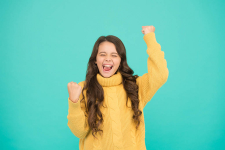 可爱的微笑女孩穿黄色毛衣绿松石背景.积极性概念.好的氛围.