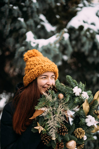 戴橙色帽子微笑的千禧一代女孩的生活方式肖像。下雪的圣诞节