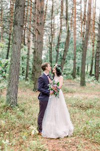 美丽的新娘和英俊的新郎在森林里