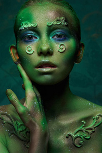 girl with creative green makeup in the image of a forest spirit