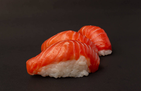 Salmon sushi on black background. 