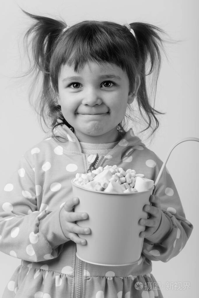 可爱的小女孩拿着一小桶棉花糖