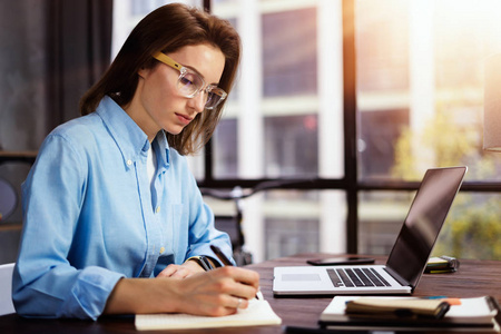 Young woman working with a laptop. Female freelancer connecting 