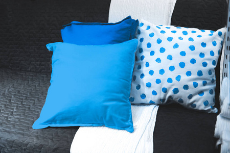 舒适的白色沙发和明亮的蓝色枕头。白色和简约的室内设计。人与家庭和谐
