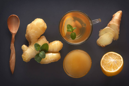 姜茶，柠檬，蜂蜜和薄荷放在灰色的木桌上。俯视图