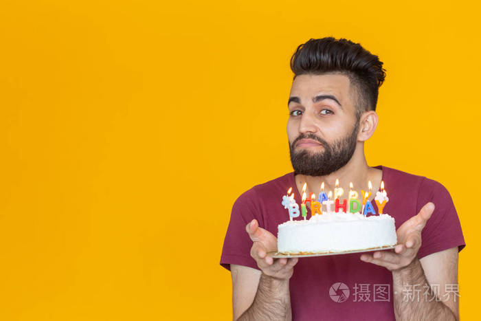 一个留着胡子的年轻男性手里拿着一个写着生日快乐的蛋糕祝贺结婚纪念