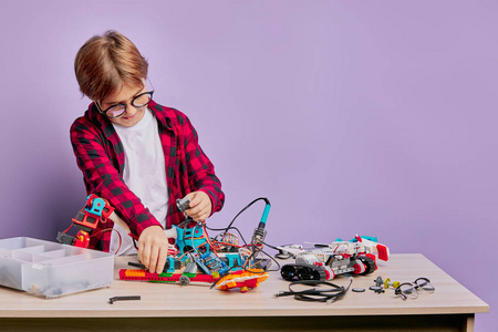 白人小孩对组装机器人感兴趣照片