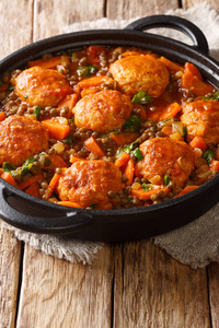 Delicious meatballs stewed with lentils and vegetables closeup 