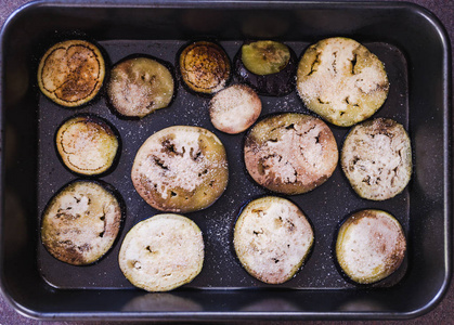 roasted aubergine slices with breadcrumbs topping in oven tray 