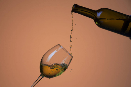 从酒杯里倒出来的酒用五颜六色的液体照片