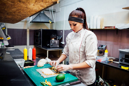 女厨师在厨房准备寿司店照片