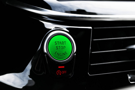 汽车仪表板与重点在发动机启动停止按钮。现代汽车内饰细节。启动停止按钮。车在里面。点火遥控起动器