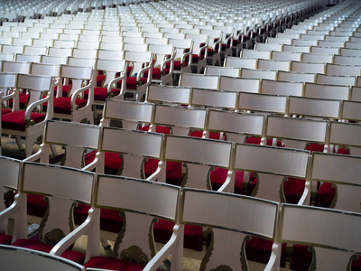 many empty red chairs in an old concert hall 