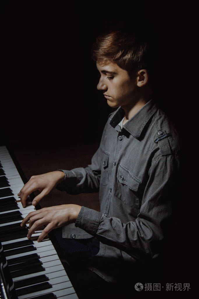 学生学会玩.手钢琴家.黑色-深色背景.垂直的.