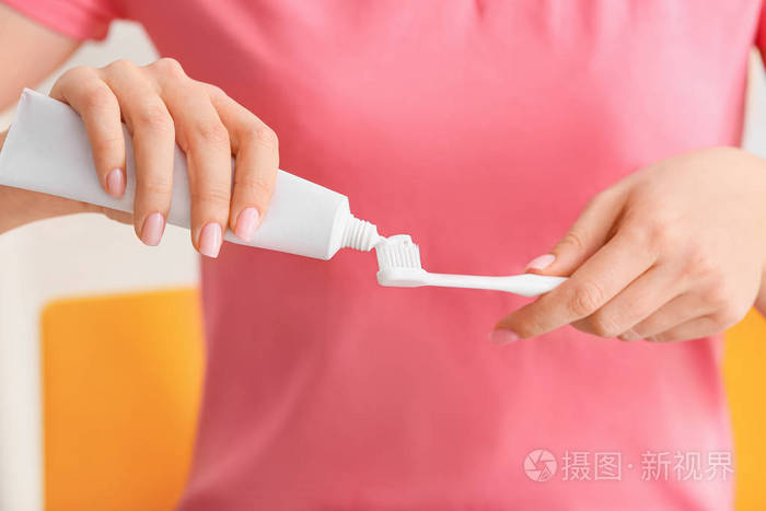 女人在刷子上挤牙膏特写