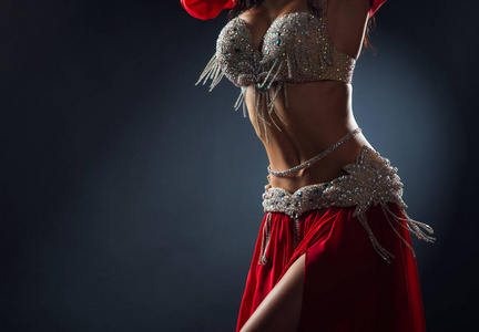 Beautiful belly dance of a girl in a red decorated ethnic dress 