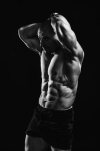 光头无袖男健美运动员的健身肖像，完美的六件套，促进运动和训练。