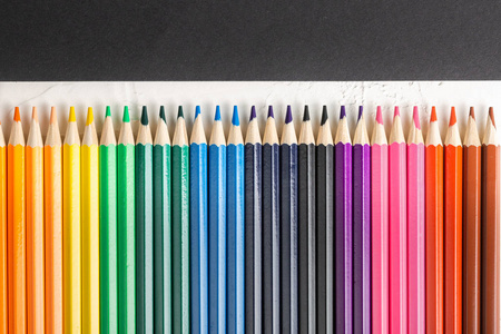 黑色背景上一排排的彩色铅笔