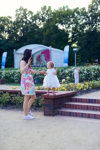 Happy mother and daughter in the park. Beauty nature scene with 