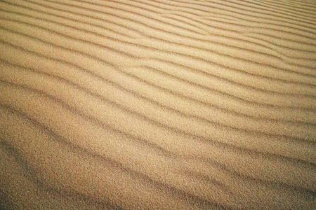 波浪状沙纹。越南梅讷。阳光下的黄色沙丘。阳光照在沙滩上