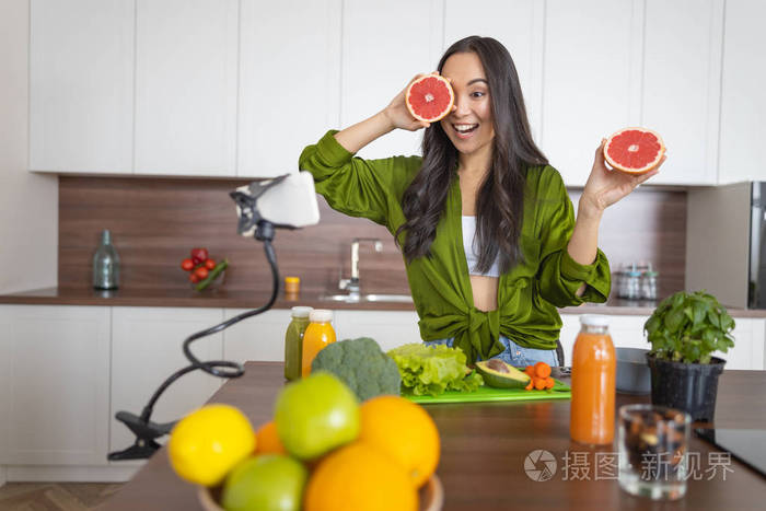 快乐的年轻亚洲女人吃柑橘类水果