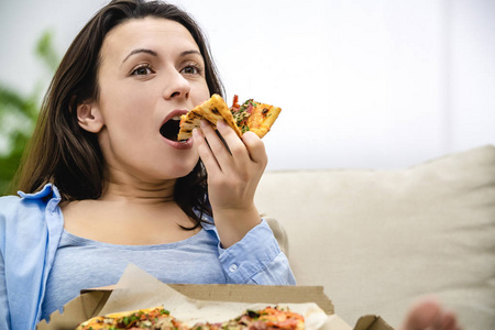 满意快乐的女人喜欢吃披萨。闭合。复制空间。