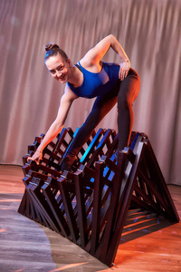 柔美的体操姑娘在大厅或舞台上用椅子做体操。穿着运动服跳跃的年轻女子。表演和摆造型演员或舞蹈模特