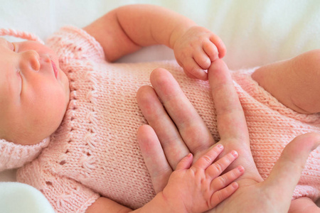 一个刚出生的女孩用自己的手握住妈妈的手掌