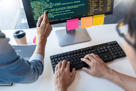 Young startup Programmers Sitting At Desks Working On Computers 