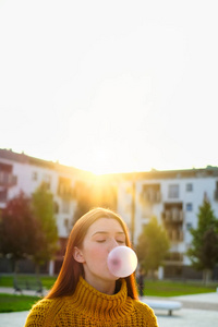 年轻女人嚼着口香糖做大气球图片