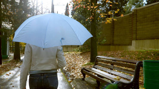  woman in white leather jacket  walking in the autumn Park with 