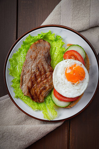 Fried egg and steak with vegetables 