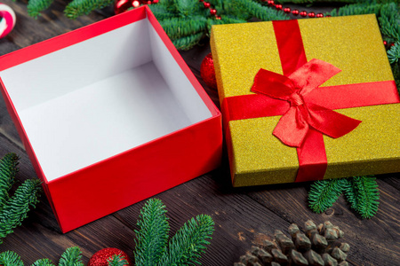 Empty festive gift box on a wooden table surrounded by fir branc