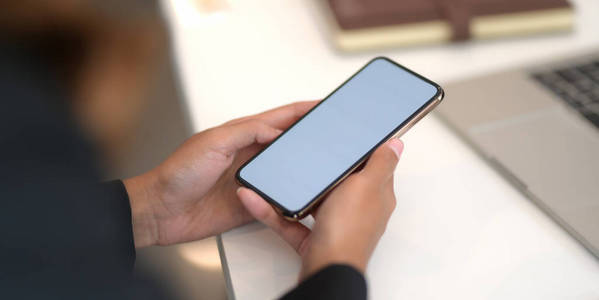 Closeup view of young businesswoman using blank screen smartpho