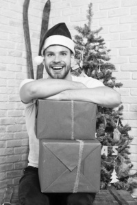 圣诞老人微笑着拿着圣诞树上的盒子