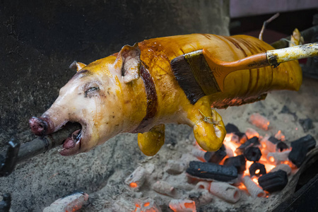 用刷子沾了油的猪嘴上的猪.烤猪肉.照片