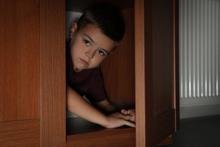 可怜的小男孩躲在衣柜里。概念